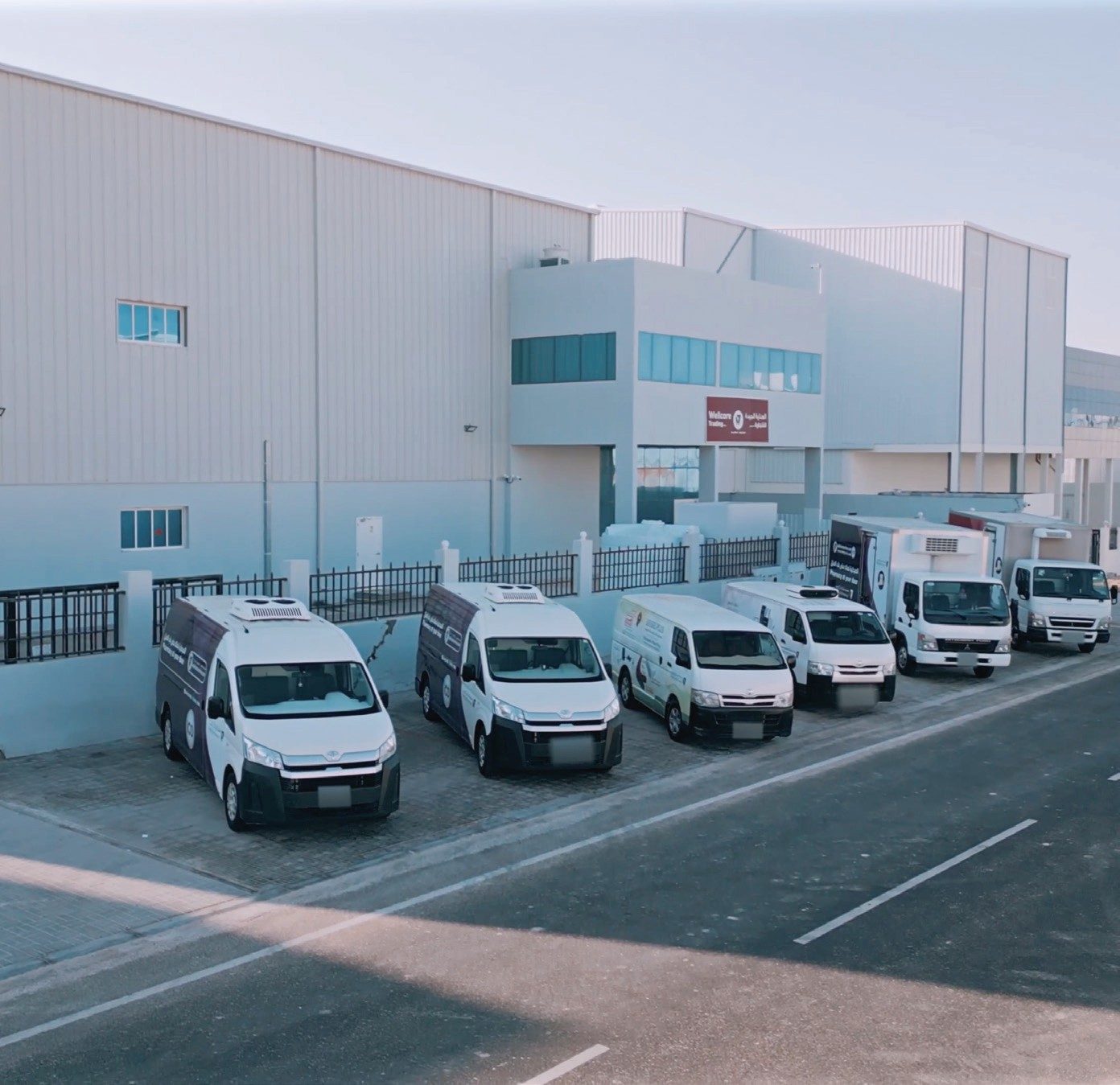 Wellcare distribution warehouse with its delivery fleet parked outside