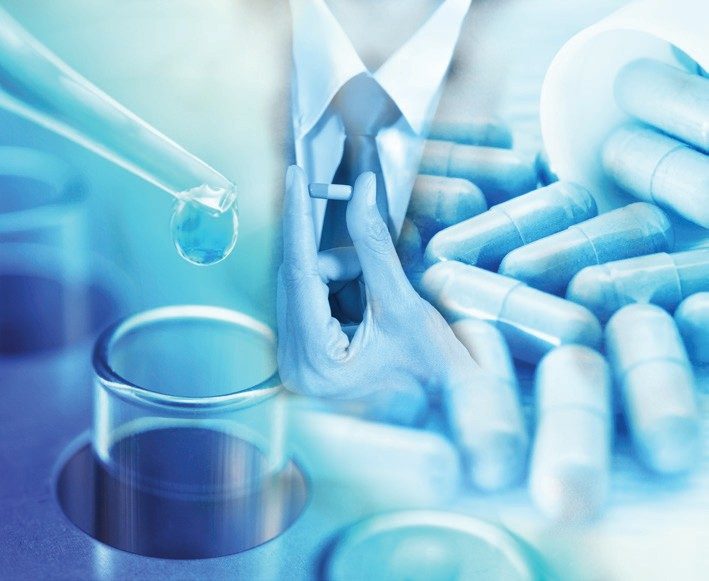 A pharmaceutical professional in a laboratory coat handling capsules